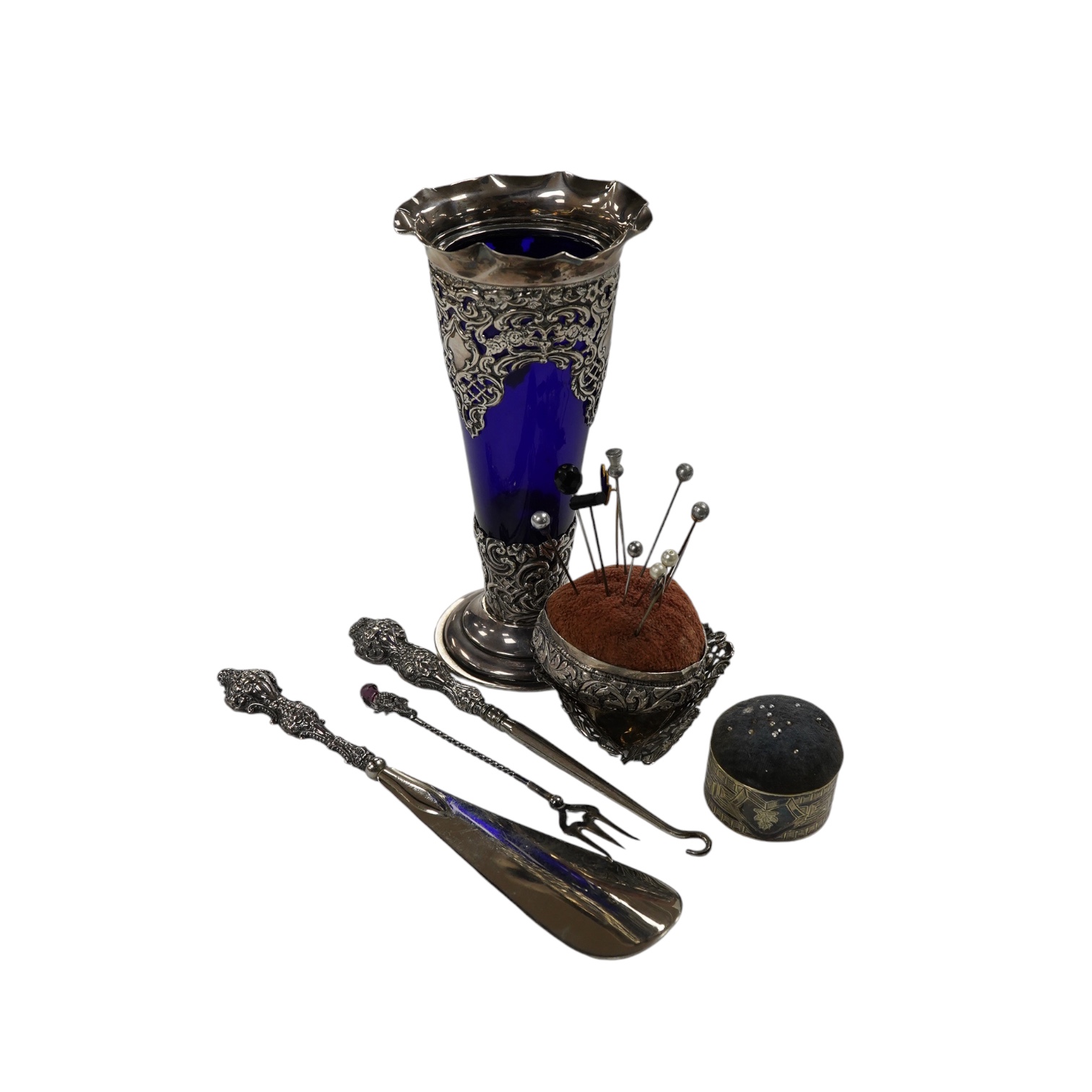 A small group of assorted silver items including mounted blue glass spill vase, 17.2cm, mounted shoe horn and button hook and a trinket dish, together with two other items. Condition - poor to fair